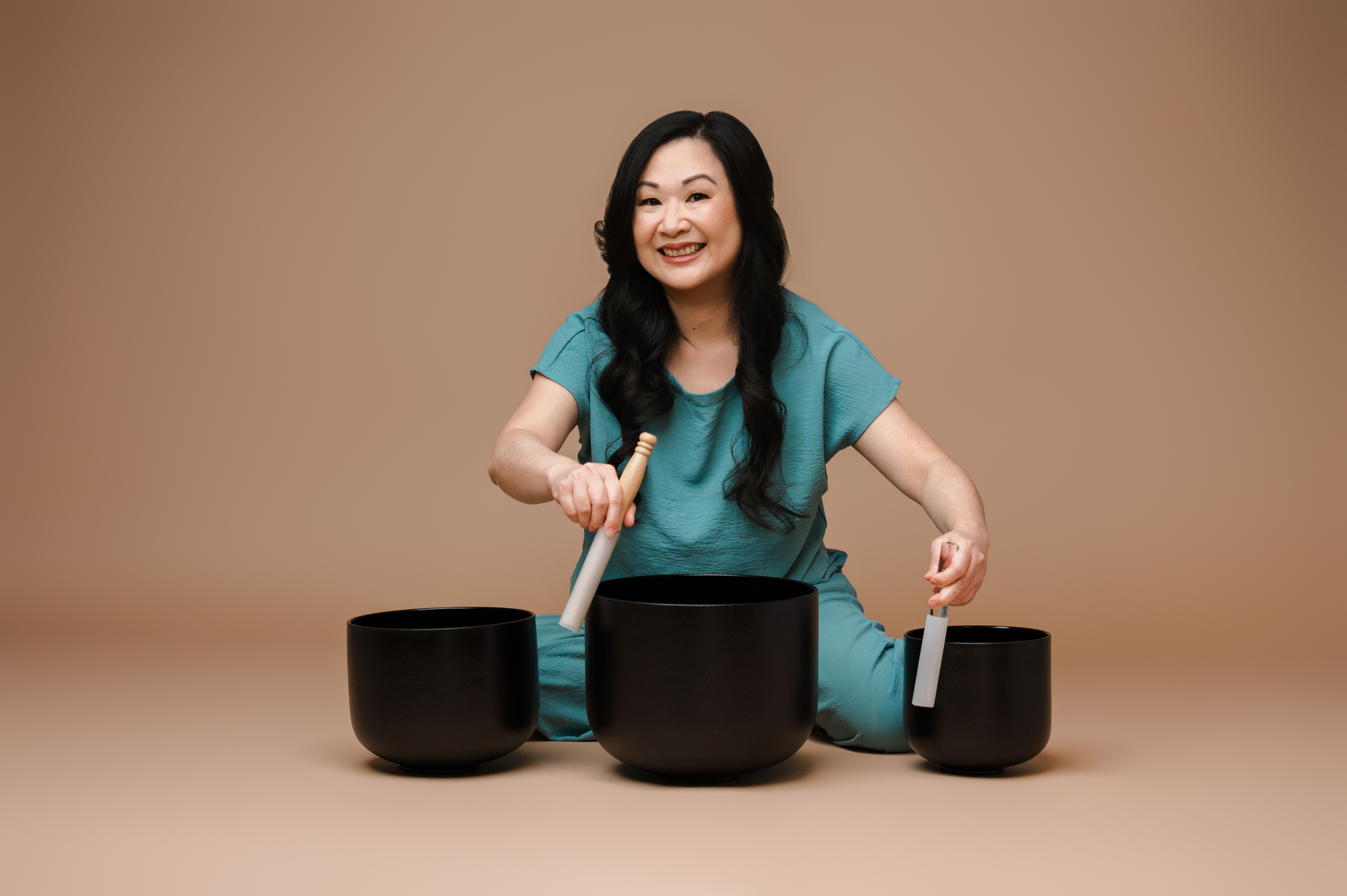 Cinsy, founder of Harmonic Glowing, playing black crystal singing bowls